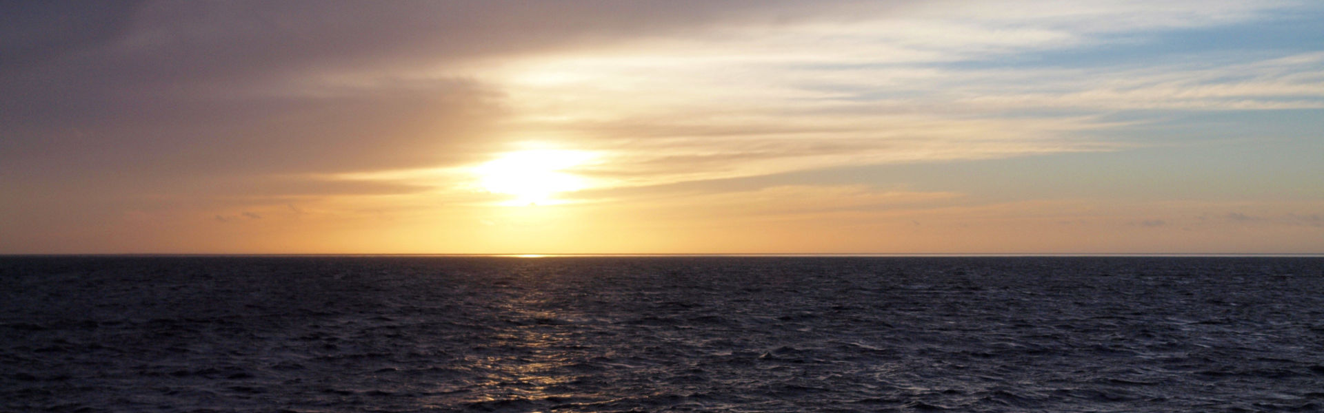 Meer mit Sonnenuntergang im Hintergrund